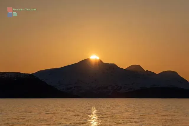 Die Mitternachtssonne über der Insel Reinøya im Ullsfjord in Norwegen